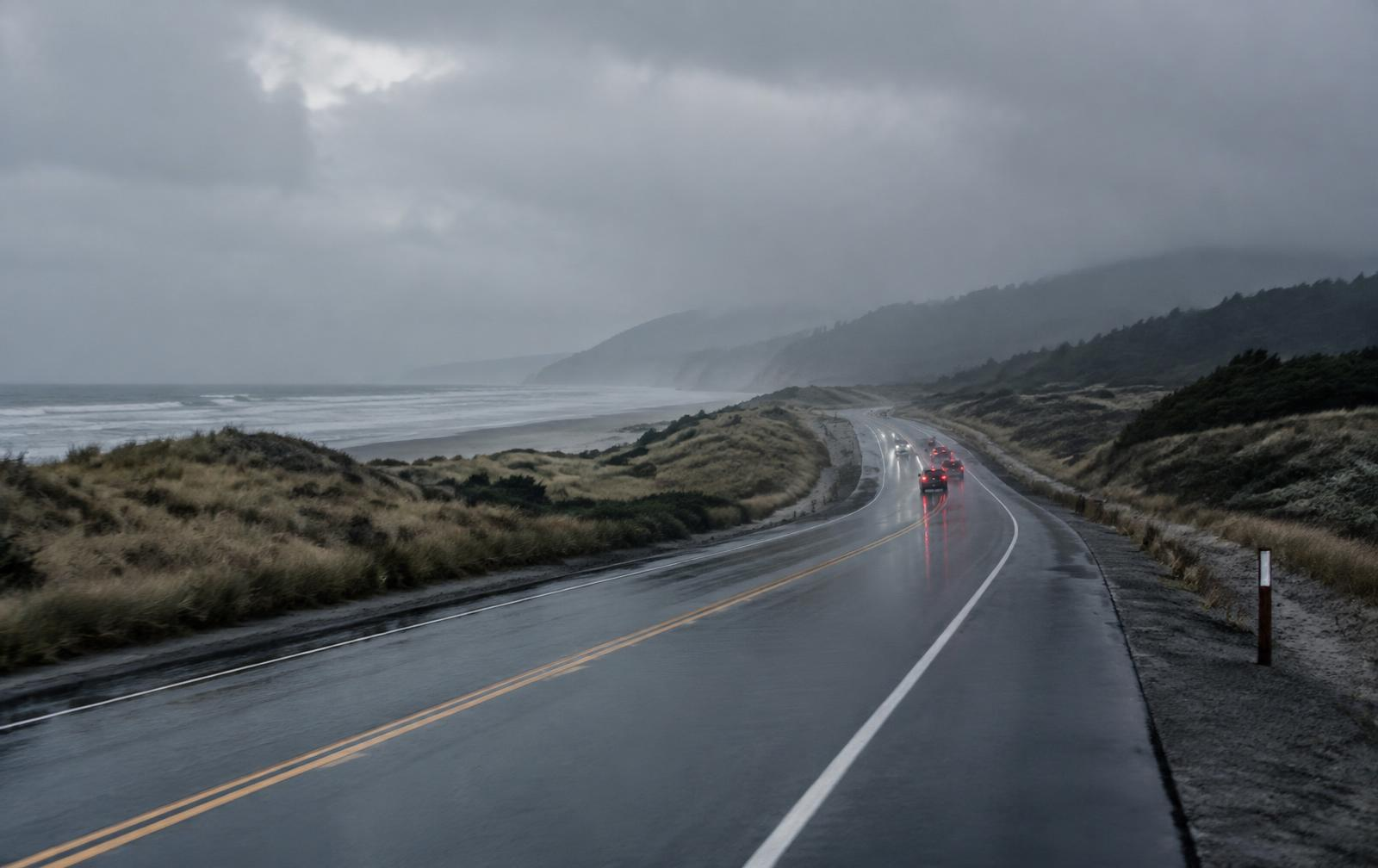 Wet coastal highway near Ocean Shores, Washington, with vehicles driving through rain, illustrating potential hydroplaning