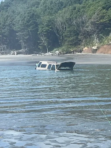 Stuck vehicle partially submerged in sand near Ocean Shores beach, Beck's Towing recovery.